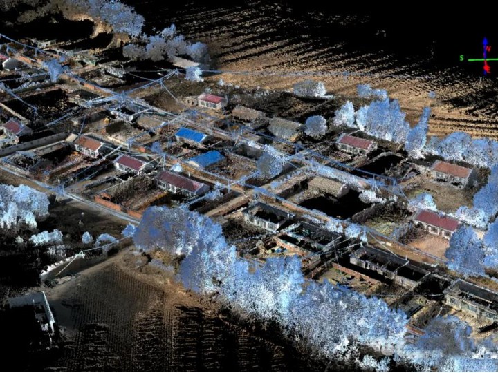 Aerial point cloud of a rural settlement with buildings, trees and power lines captured for infrastructure inspection.
