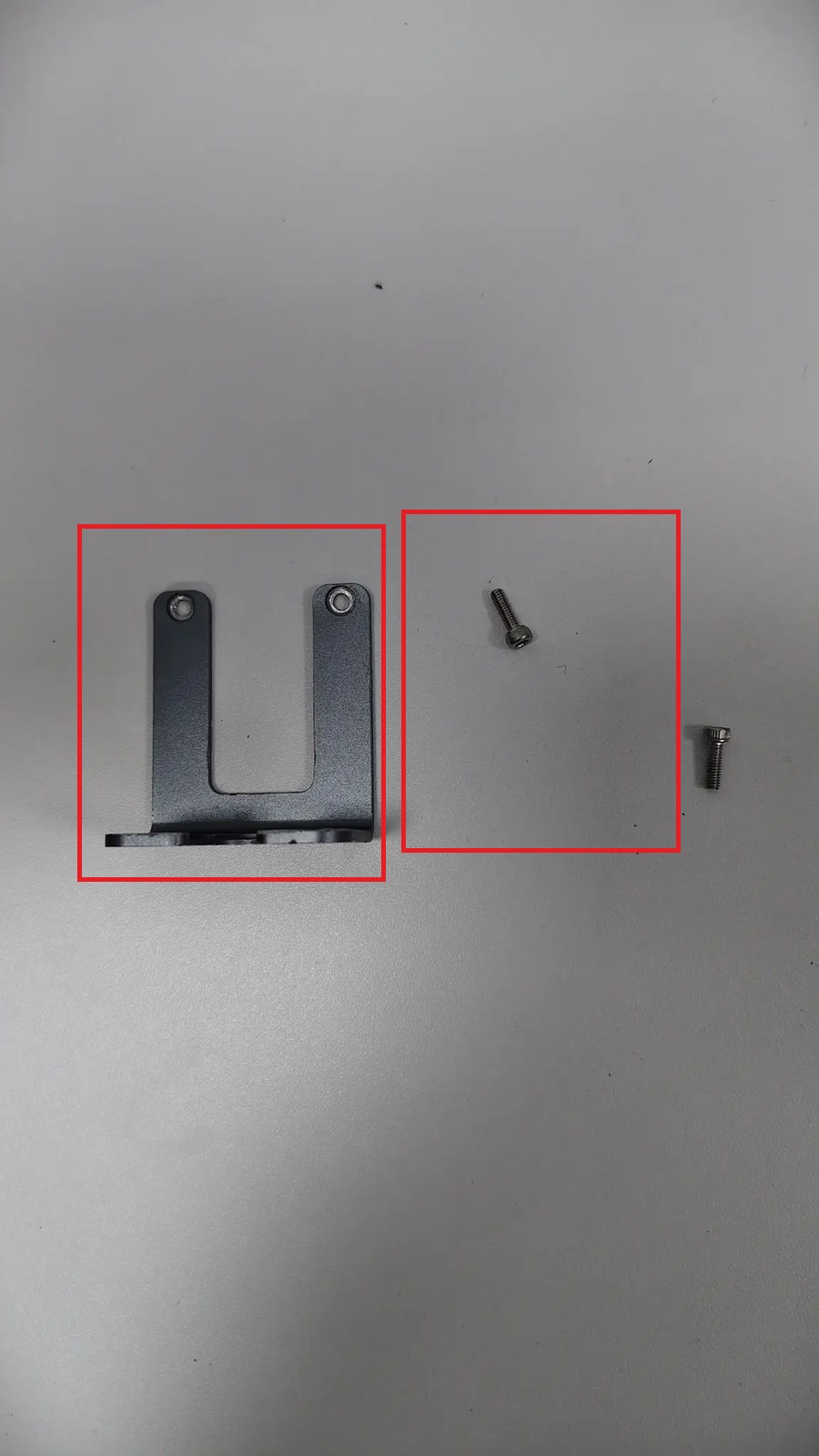 Zdjęta metalowa część w kształcie litery U i jej dwie śruby